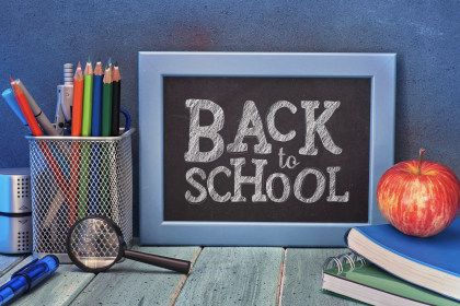 A blackboard with 'back to school' written on it in white chalk